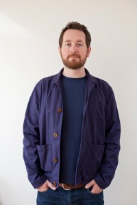 Author photo of illustrator Chris Judge standing in front of a wall