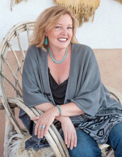 Photo of author Natalie Bovis sitting in an outdoor chair and smiling at the camera